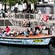 Passengers aboard a tour boat docked alongside the canal